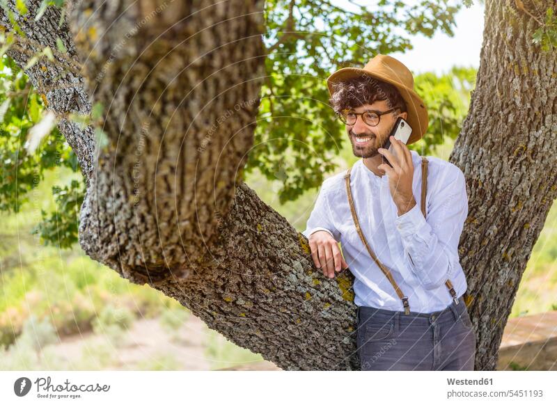 Smiling man wearing old-fashioned clothes talking on cell phone smiling smile men males on the phone call telephoning On The Telephone calling mobile phone