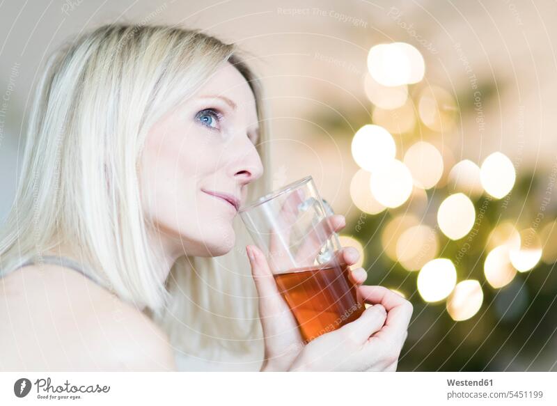 Blond woman enjoying glass of tea Tea Teas indulgence enjoyment savoring indulging blond blond hair blonde hair Drink beverages Drinks Beverage food and drink