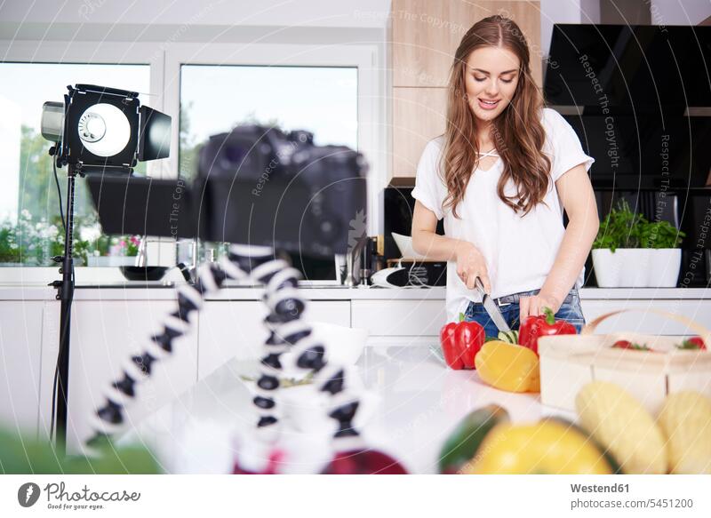 Woman recording while chopping vegetables cameras cook smile domestic kitchen kitchens human human being human beings humans person persons adult grown-up