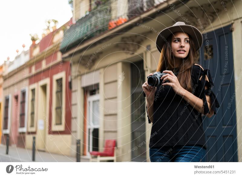 Portrait of smiling young woman with camera outdoors portrait portraits females women cameras Adults grown-ups grownups adult people persons human being humans