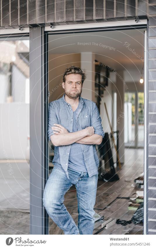 Mature man standing in door of his new home building men males flat flats apartment apartments property owner owners moving house move Moving Home Adults