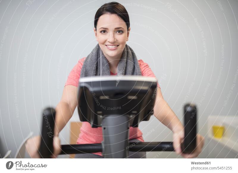 Smiling woman on exercise machine in medical practice smiling smile exercise machines stationary bike Stationary Bikes fit exercise equipment
