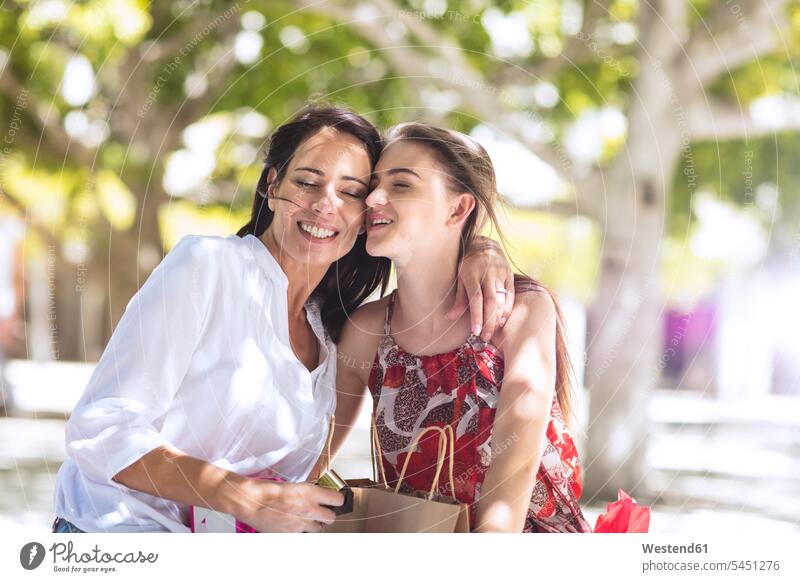 Happy mother and daughter with shopping bags embracing in the city shopping-bag shopping-bags happiness happy embrace Embracement hug hugging buying together
