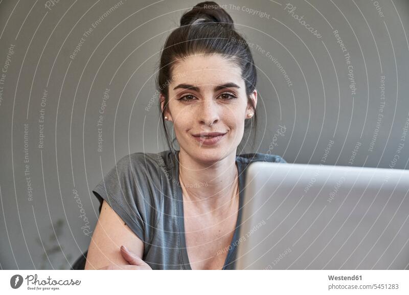 Portrait of smiling young woman with laptop portrait portraits females women Adults grown-ups grownups adult people persons human being humans human beings