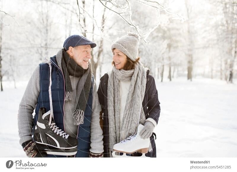 Senior couple with ice skates in winter landscape twosomes partnership couples ice skater skaters ice skaters forest woods forests Fun having fun funny people