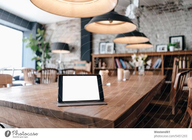 Digital tablet on a table in a cafe lamp lamps Absence Absent Networking accessibility accessible wireless Wireless Connection Wireless Technology