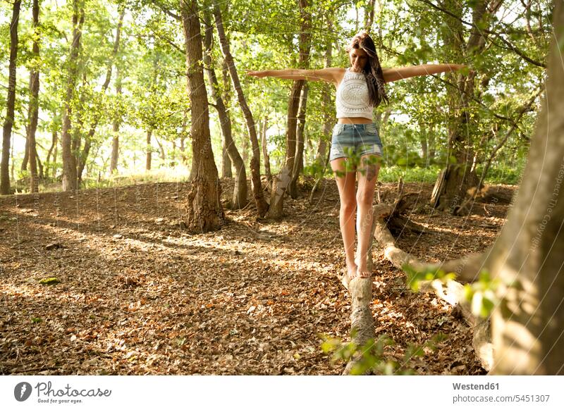 Young woman in forest balancing on a log Tree Trees woods forests balance females women Balance Equilibrium balanced Adults grown-ups grownups adult people