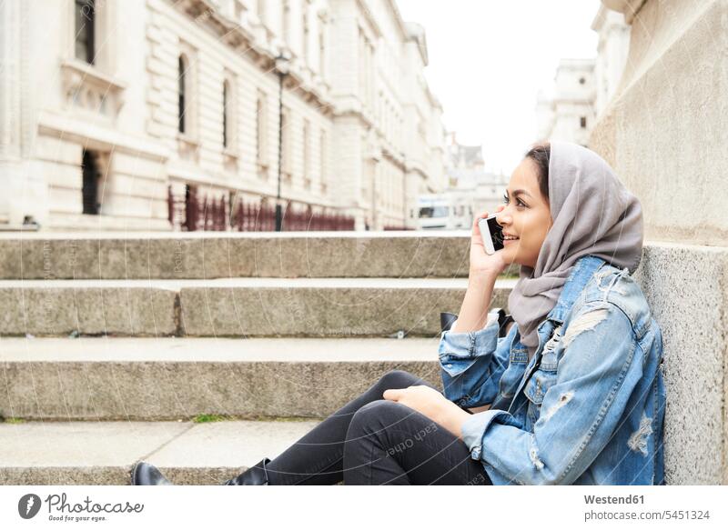 UK, England, London, young woman wearing hijab on cell phone in the city headscarf head scarf head scarves Head Scarf head cloths headscarves stairs stairway