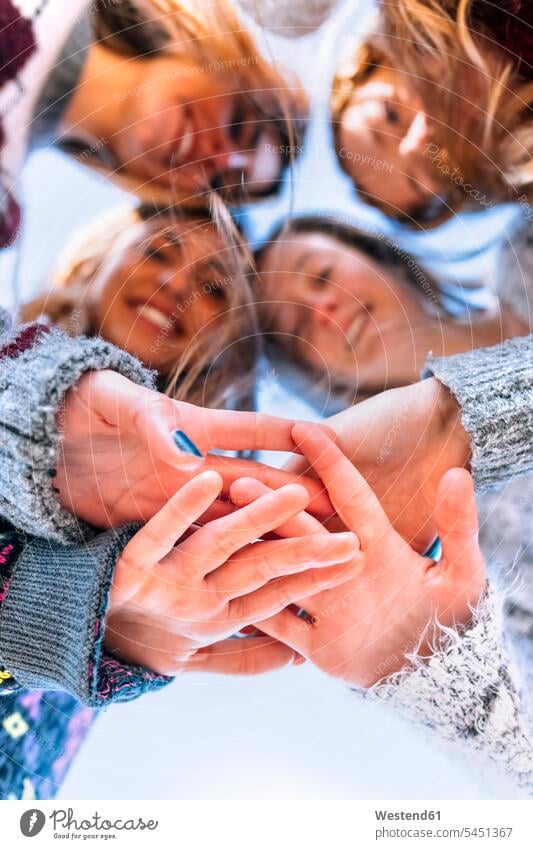 Four friends joining hands, close-up mate female friend human human being human beings humans person persons human hand human hands caucasian appearance