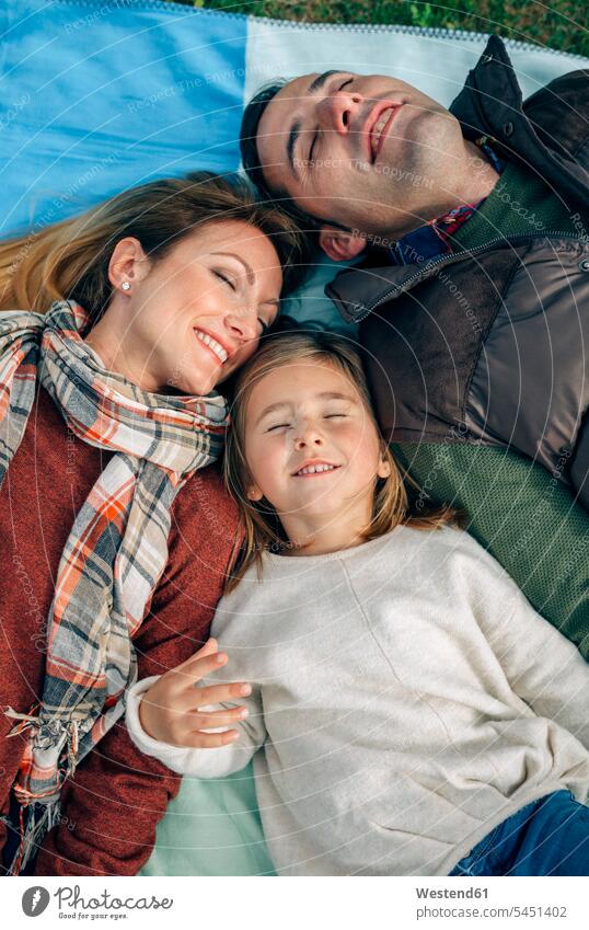 Happy family lying on blanket with closed eyes laying down lie lying down Blanket Blankets happiness happy smiling smile relaxed relaxation families relaxing