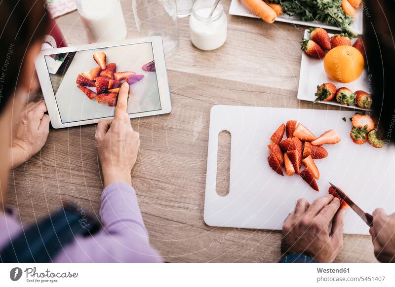 Woman taking picture with tablet while her friend chopping strawberries, partial view digitizer Tablet Computer Tablet PC Tablet Computers iPad Digital Tablet