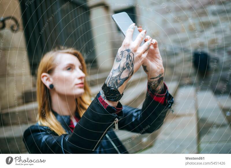 Tattooed woman's hands taking selfie with cell phone Selfie Selfies tattoo tattoos tattooed body art Body Adornment Skin Art style stylish human hand