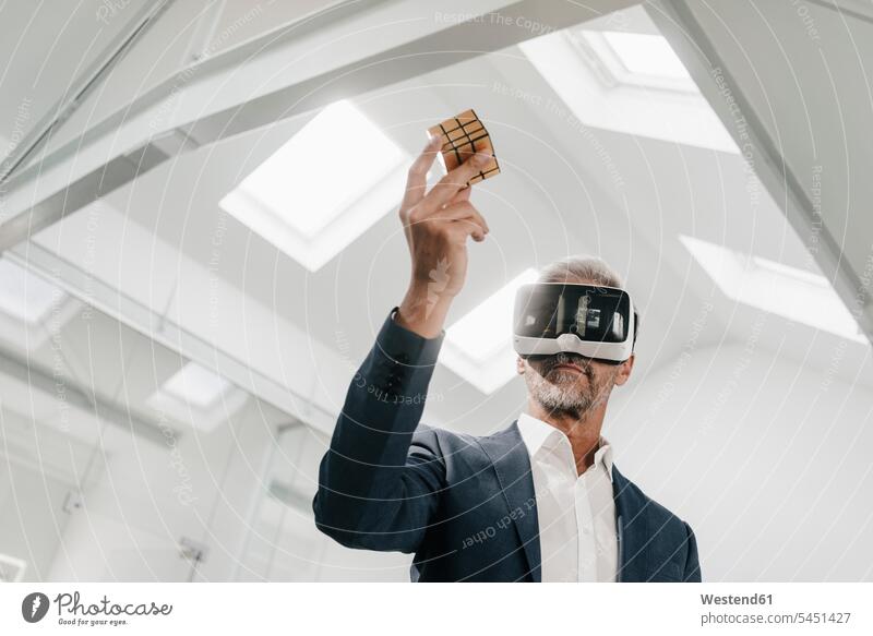 Mature businessman in office wearing VR glasses holding Rubik's Cube Businessman Business man Businessmen Business men 3D Glasses 3-D Glasses business people