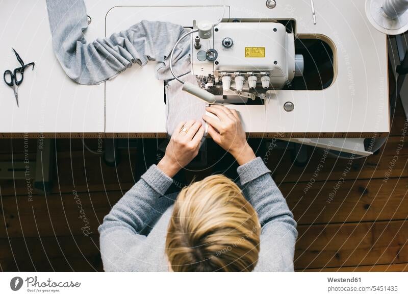 Top view of woman using sewing machine females women seamstress seamstresses working At Work sewing machines Adults grown-ups grownups adult people persons