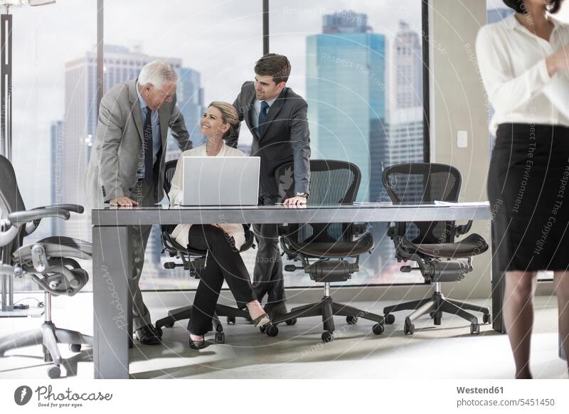Group of businesspeople with laptop discussing in office talking speaking colleagues offices office room office rooms Laptop Computers laptops notebook