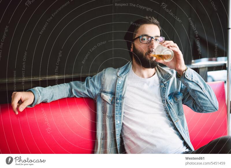 Young man drinking glass of beer in a pub Beer Beers Ale men males Alcohol alcoholic beverage Alcoholic Drink Alcoholic Drinks alcoholic beverages Beverage