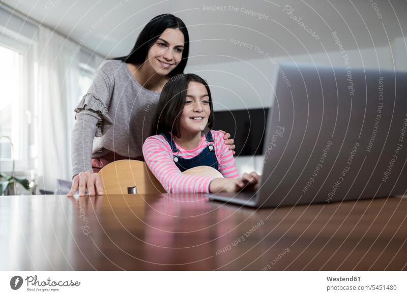 Mother and daughter smiling in front of laptop with daughter holding a guitar mother mommy mothers ma mummy mama Laptop Computers laptops notebook guitars smile