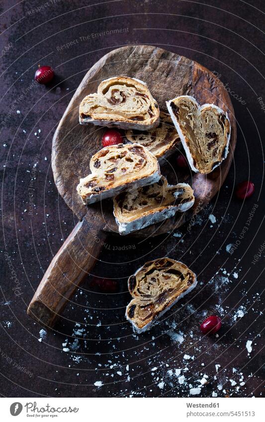 Sliced Christmas Stollen with icing sugar on a wooden scoop baking bake cut scoops Christmas pastry Christstollen wooden spoon wooden spoons sliced Slices