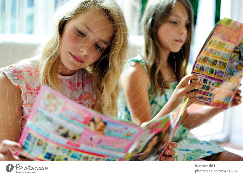 Two girls reading teen magazine females magazines female friends child children kid kids people persons human being humans human beings journal journals mate