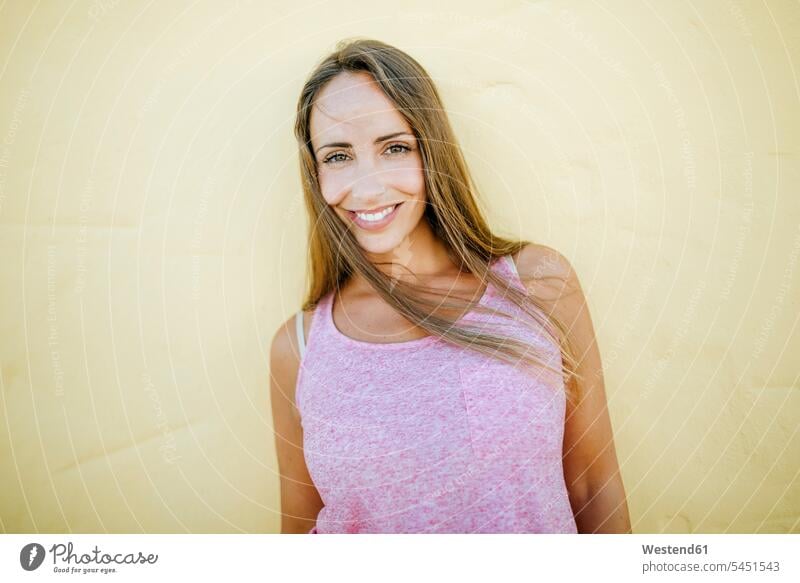 Portrait of smiling woman at yellow wall smile females women happiness happy portrait portraits Adults grown-ups grownups adult people persons human being