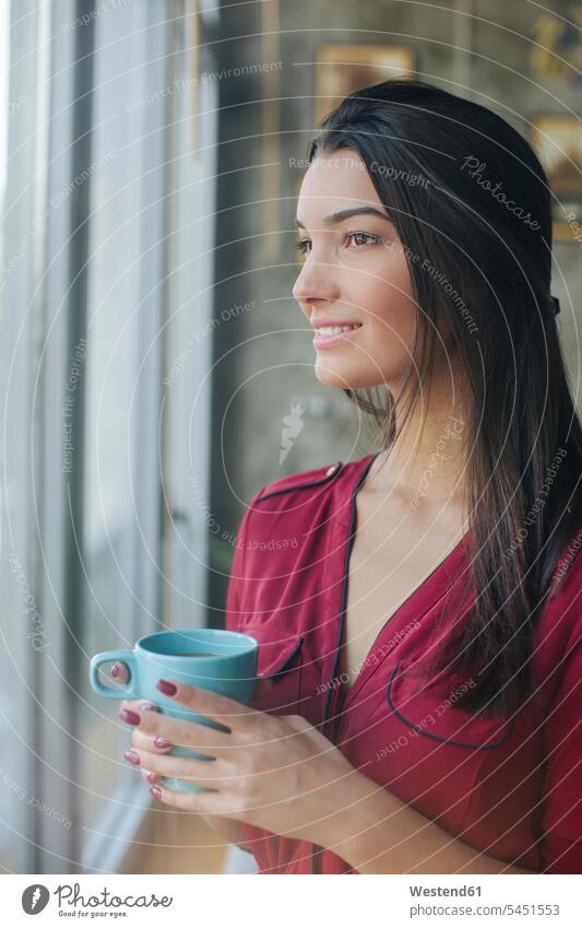 Woman drinking tea and looking through window woman females women view seeing viewing windows portrait portraits Tea Cup Tea Cups Teacup Teacups smiling smile