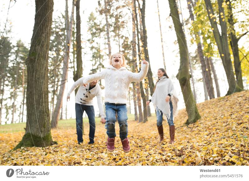 Happy girl with family in autumnal forest woods forests females girls happiness happy Fun having fun funny families child children kid kids people persons