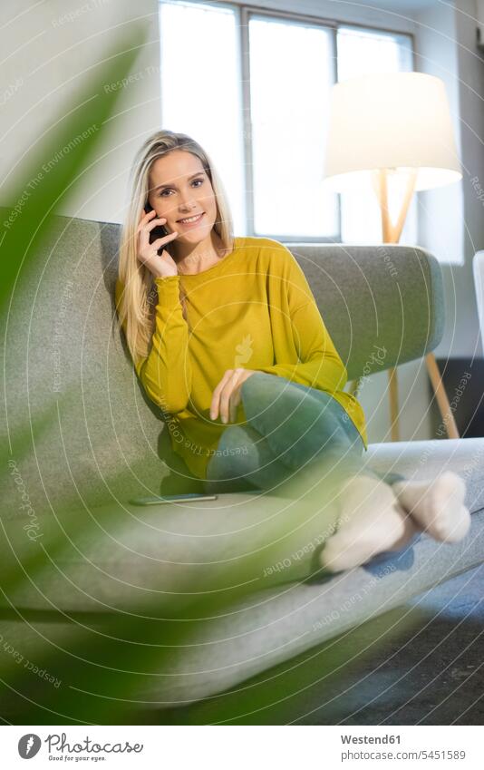 Portrait of smiling young woman on the phone at home females women call telephoning On The Telephone calling portrait portraits Adults grown-ups grownups adult