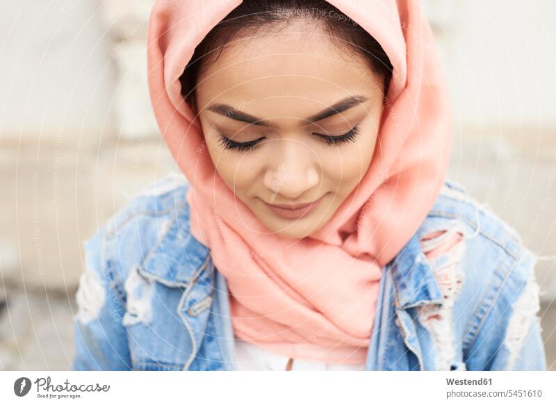 Close-up of young woman wearing hijab looking down Muslim females women headscarf head scarf head scarves Head Scarf head cloths headscarves portrait portraits