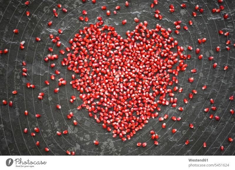 Heart shaped of pomegranate seeds on slate food and drink Nutrition Alimentation Food and Drinks symbolical picture Symbolism copy space heart heart-shape