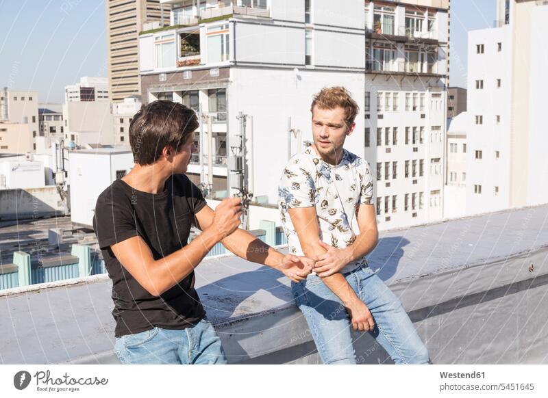 Friends talking on a rooftop terrace caucasian caucasian ethnicity caucasian appearance european communication telecommunication leisure free time leisure time