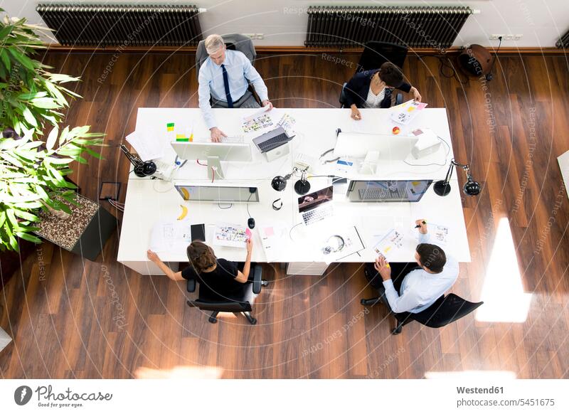 Business people in planning office sitting at desk, working together desks Cooperation collaboration Cooperating Cooperate Co-Operation Collaborating