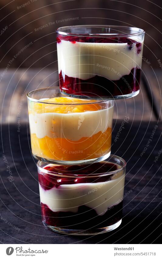 Red and yellow fruit compote with vanilla sauce layered in glasses nobody on top of Cherry Cherries Orange Oranges Layers Berry berry fruits Berries Peach