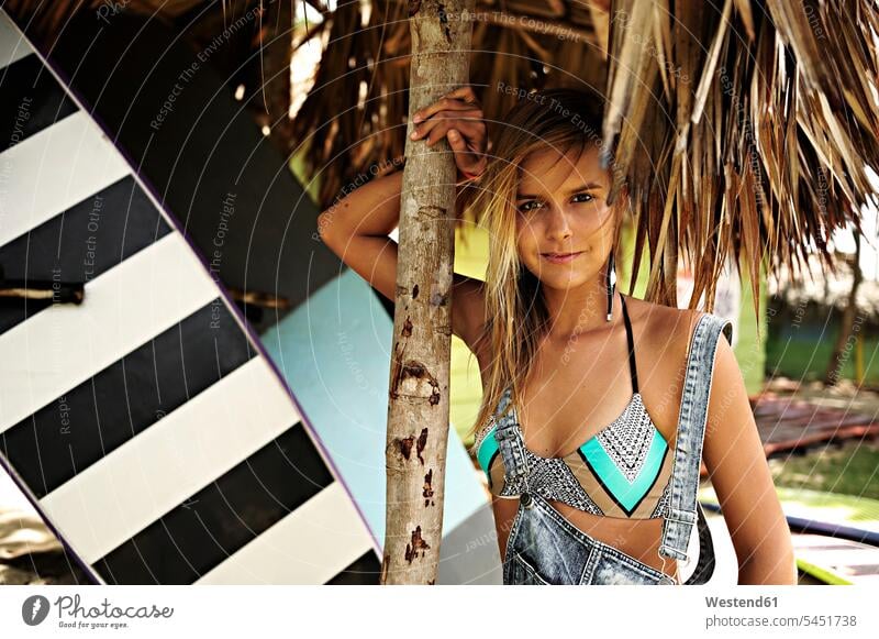 Portrait of woman with surfboard under straw roof surfing surf ride surf riding Surfboarding surfboards portrait portraits females women water sports