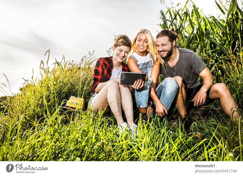 Friends sharing tablet at a cornfield digitizer Tablet Computer Tablet PC Tablet Computers iPad Digital Tablet digital tablets relaxed relaxation friends mate