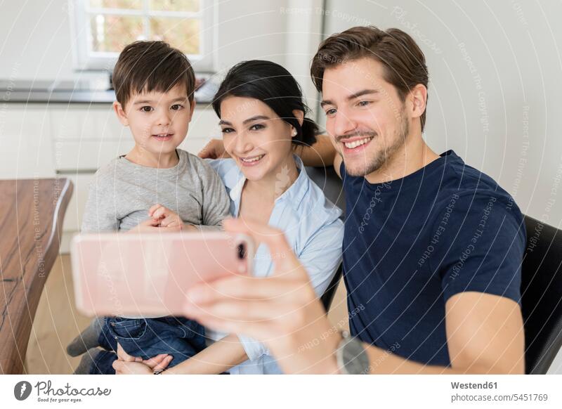 Happy family taking a selfie at home families mobile phone mobiles mobile phones Cellphone cell phone cell phones smiling smile Selfie Selfies people persons