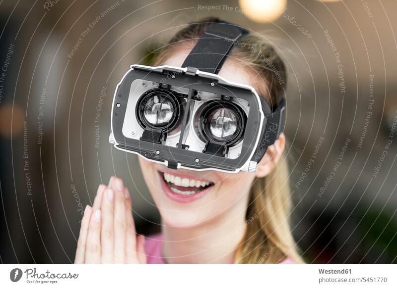 Happy young woman wearing VR glasses happiness happy specs Eye Glasses spectacles Eyeglasses virtual reality females women Adults grown-ups grownups adult