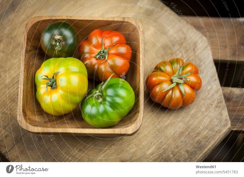 Wooden bowl of various Oxheart Tomatoes nobody different variation Vegetable Vegetables raw gleaming wood bowl wooden bowl wood bowls wooden bowls