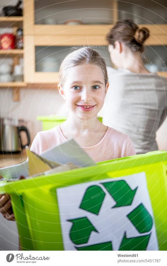 Portrait of smiling girl at home holding waste box boxes females girls smile Rubbish recycling ecology recycle child children kid kids people persons