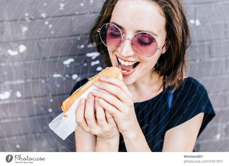 Portrait of woman eating a Hot Dog females women hot dog Hotdog Hot-Dogs hot dogs Hotdogs Adults grown-ups grownups adult people persons human being humans