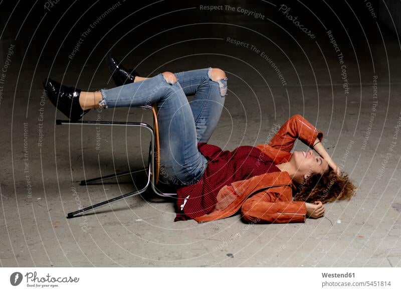 Laughing woman lying on the floor with chair laughing Laughter laying down lie lying down females women positive Emotion Feeling Feelings Sentiments Emotions