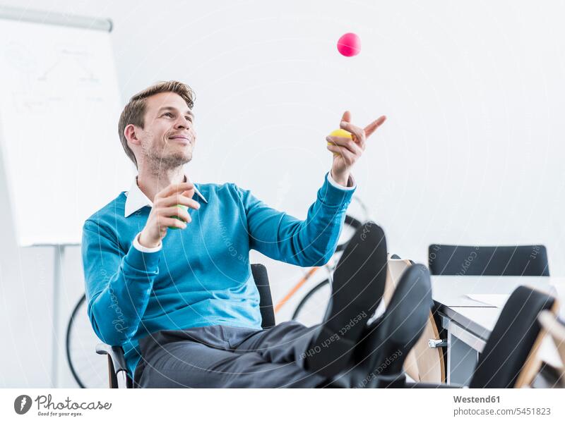 Smiling businessman juggling with balls in office Businessman Business man Businessmen Business men smiling smile juggle offices office room office rooms
