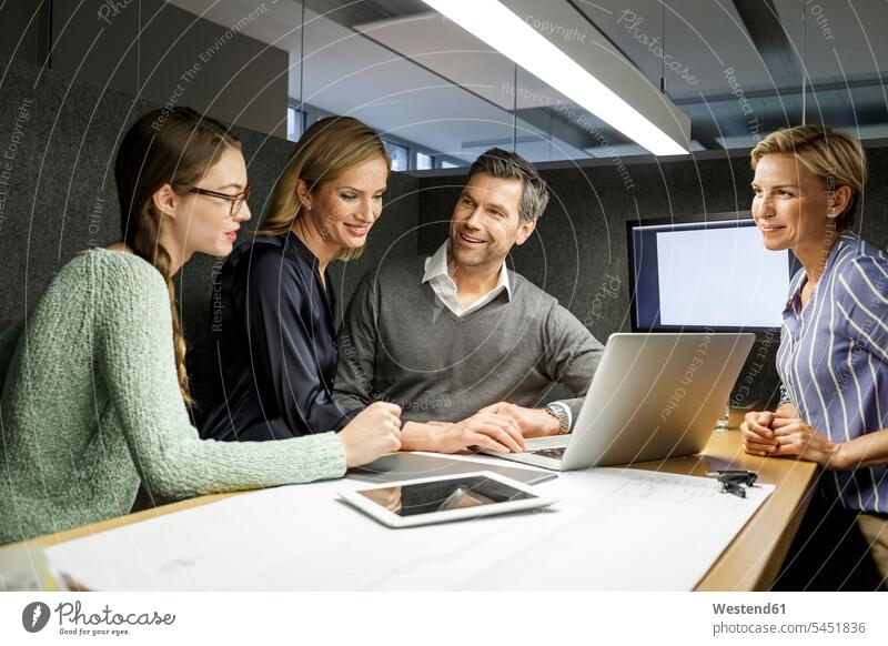 Colleagues with laptop having a meeting in meeting box Laptop Computers laptops notebook Business Meeting business conference smiling smile business people