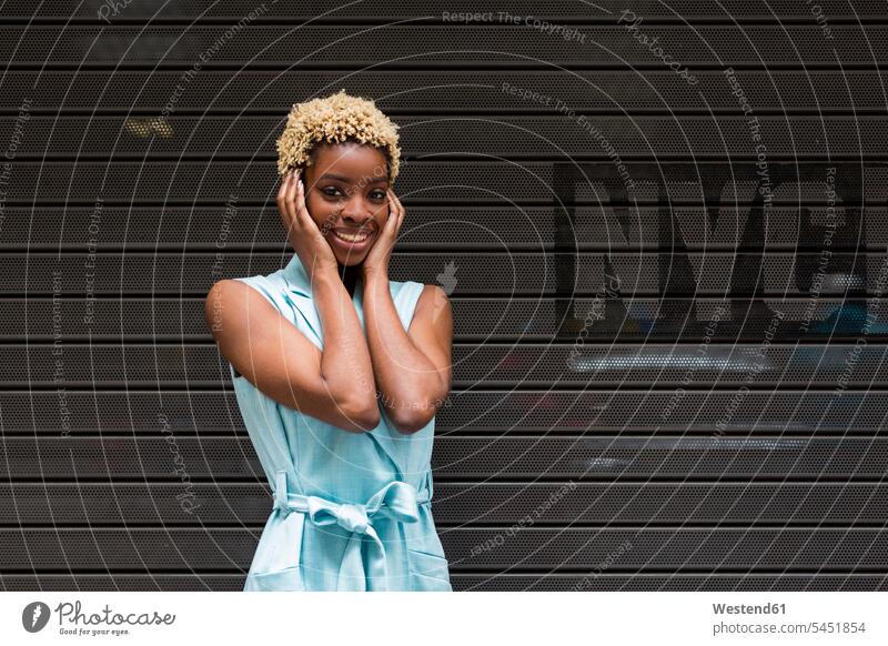 USA, New York, happy young blonde african-american woman, smiling, hand on head African-American Ethnicity Afro-American African American Ethnicity