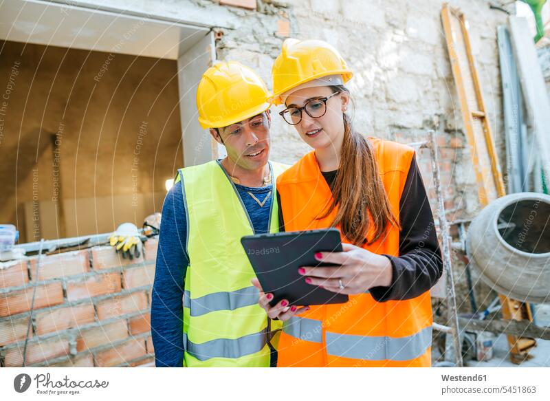 Woman with tablet talking to construction worker on construction site Building Site sites Building Sites construction sites digitizer Tablet Computer Tablet PC