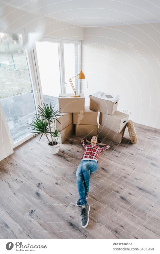 Mature woman moving house, lying on floor, thinking females women flat flats apartment apartments owner owners property move Moving Home floors ground land