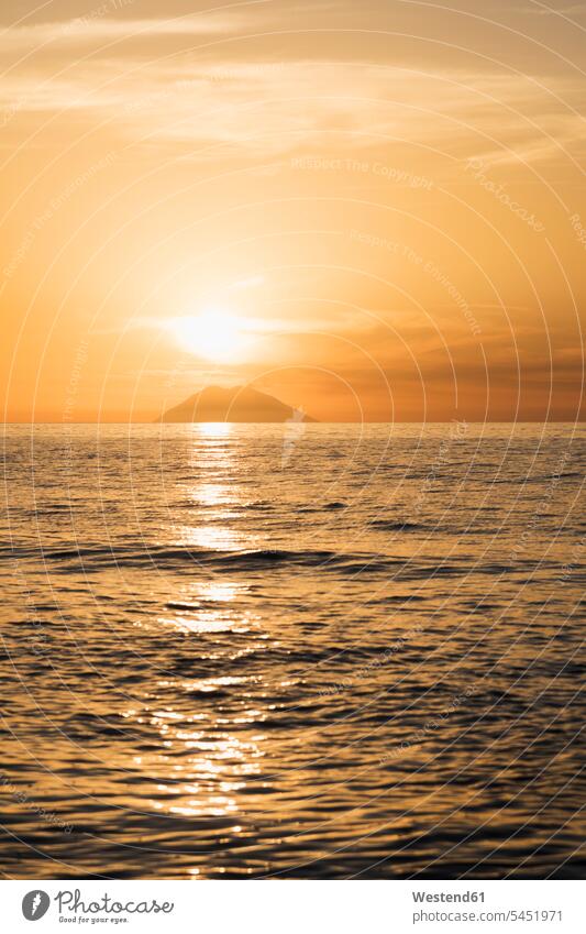 Italy, Calabria, Tropea, Tyrrhenian Sea, View to volcanic island Stromboli against the sun evening in the evening Moody Sky sea ocean evening sun setting sun