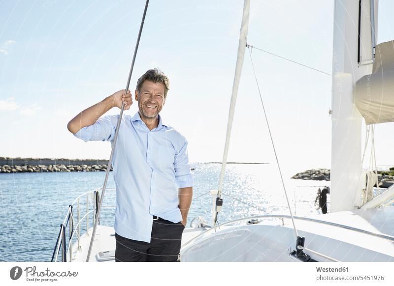 Portrait of laughing mature man on sailing boat men males Adults grown-ups grownups adult people persons human being humans human beings boat sports Sea ocean