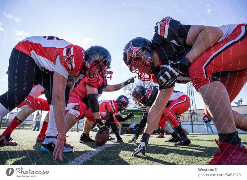 American football players on the line of scrimmage during a match helmet helmets Protective Headwear Football sport sports sports field sports fields training