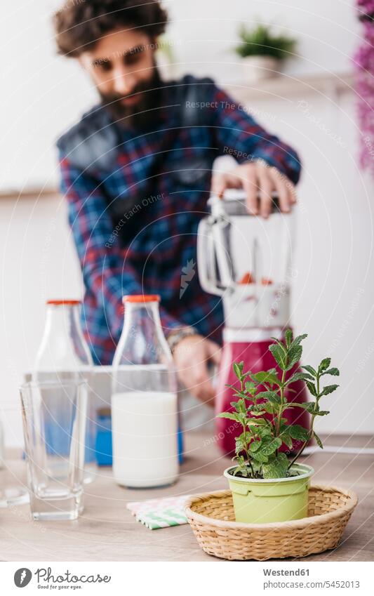 Man preparing smoothies with fresh fruits and vegetables at home Food Preparation preparing food preparation prepare kitchen domestic kitchen kitchens operating