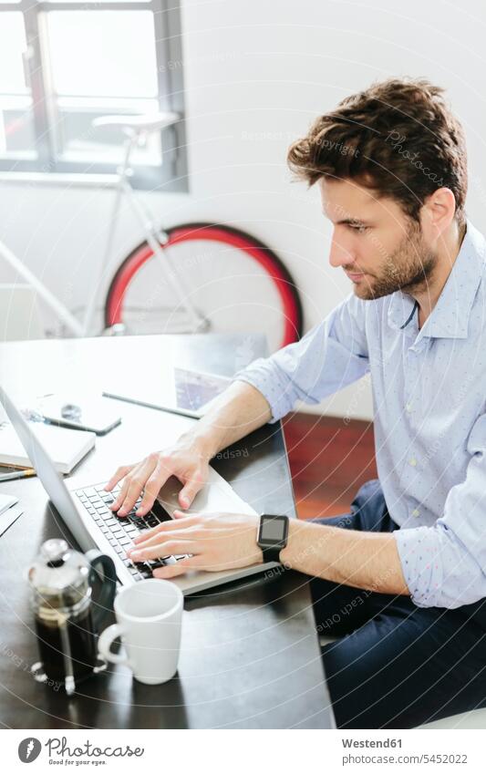 Young businessman working in office, using laptop smartwatch smart watch Coffee typing type Laptop Computers laptops notebook Businessman Business man